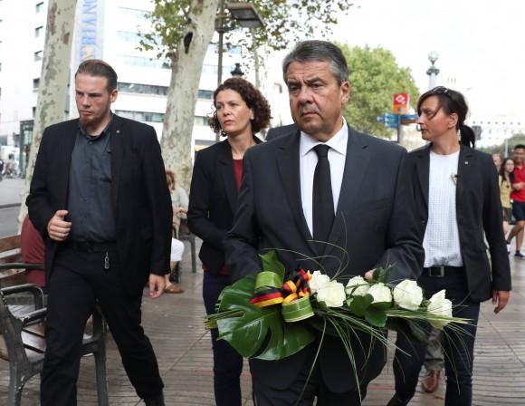 German Foreign Minister Gabriel holds flowers before placing it at an impromptu memorial where a van crashed into pedestrians at Las Ramblas in Barcelona, Spain, August 19, 2017. (Reuters/Sergio Perez)