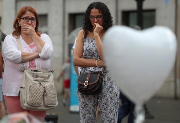 Two women react at an impromptu memorial where a van crashed into pedestrians at Las Ramblas in Barcelona, Spain, August 19, 2017. (Reuters/Sergio Perez)