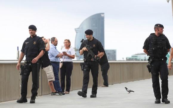 Armed Catalan Mossos d'Esquadra officers patrol along La Barceloneta beach in Barcelona, Spain, August 19, 2017. (Reuters/Sergio Perez)