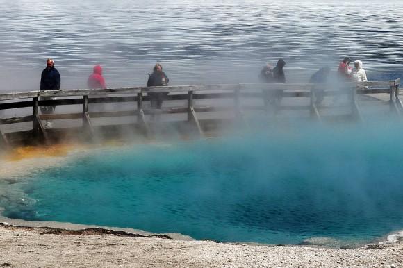 Tourists beside a hot spring and the partially frozen Yellowstone Lake at the West Thumb Geyser Basin in Yellowstone National Park, Wyoming, on June 2, 2011. (Mark Ralston/AFP/Getty Images)