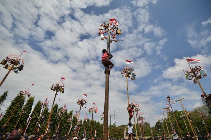 People climb greased poles, on which prizes and flags are attached, to celebrate Indonesia's Independence Day in Denpasar, Indonesia, on Aug. 17, 2017. Indonesia marked the 72nd anniversary of its independence from Dutch rule on August 17. (SONNY TUMBELAKA/AFP/Getty Images)