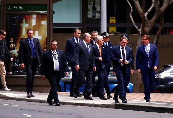 Australian Prime Minister Malcolm Turnbull walks with officials and security personnel along a street before holding a media conference announcing Australia's national security plan to protect public places in central Sydney, Australia, August 20, 2017. (Reuters/David Gray)
