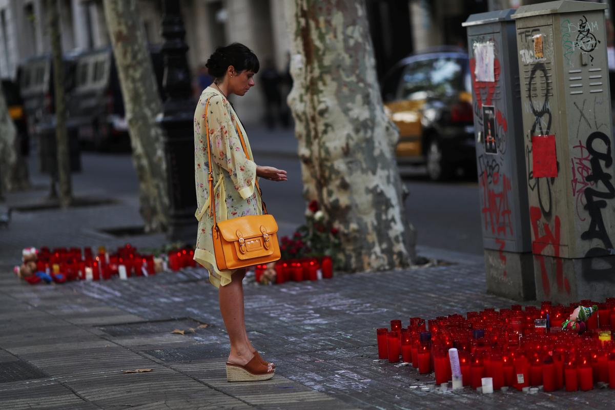 A woman reacts at an impromptu memorial where a van crashed into pedestrians at Las Ramblas in Barcelona, Spain on August 20, 2017. (REUTERS/Susana Vera)