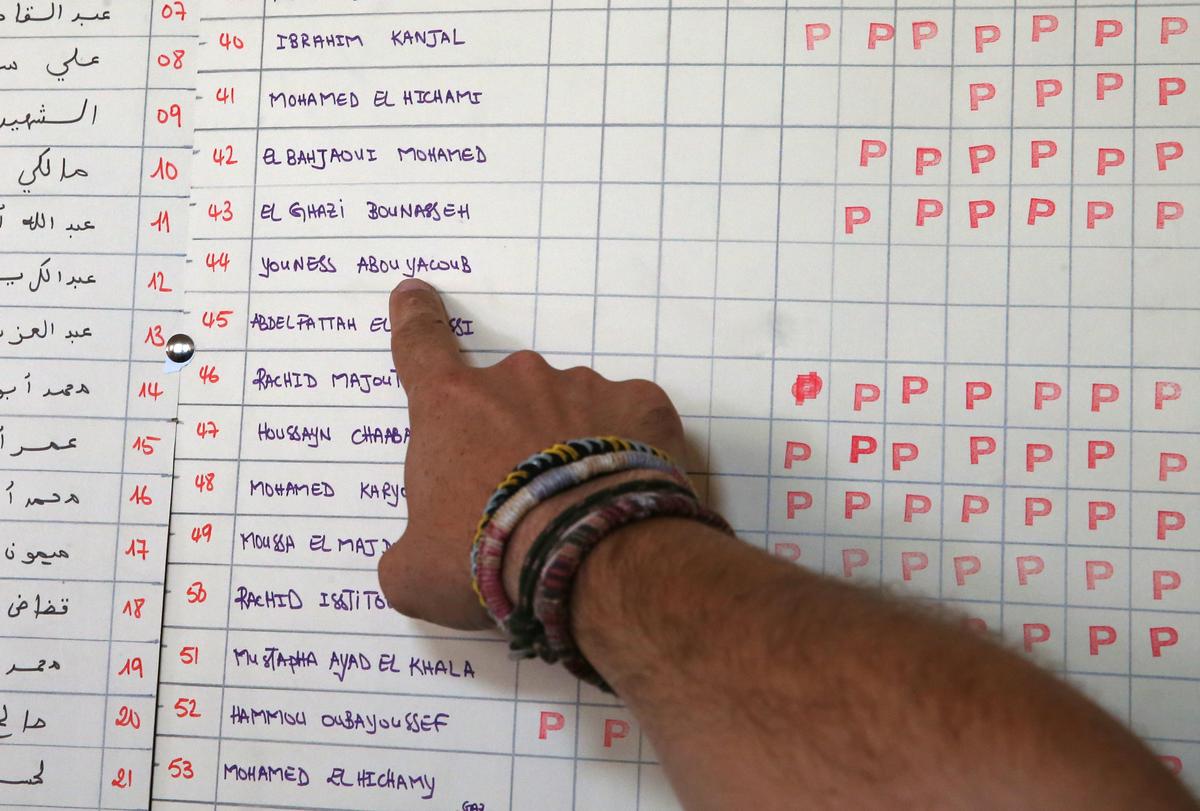 A journalist points the name of Younes Abouyaaqoub in a table of voluntary payments for the expenses of the mosque (where he didn't contribute) at a mosque where imam Abdelbaki Es Satty preached in Ripoll, north of Barcelona, Spain on August 20, 2017. (REUTERS/Albert Gea)