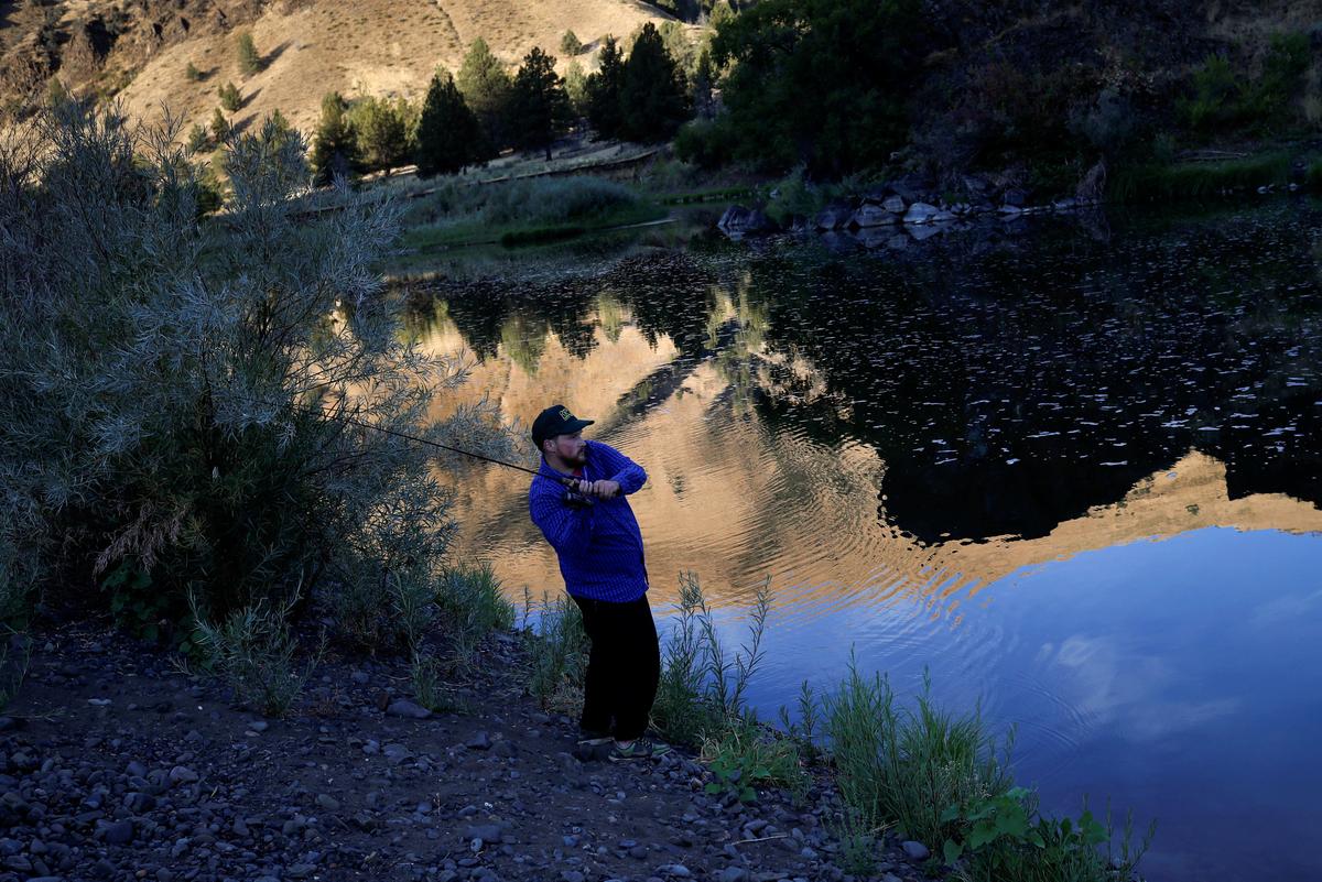 KC DeRemer fishes for bass while camping along the John Day River ahead of the total lunar eclipse in Kimberly, Oregon, U.S. August 20, 2017. (REUTERS/Adrees Latif)