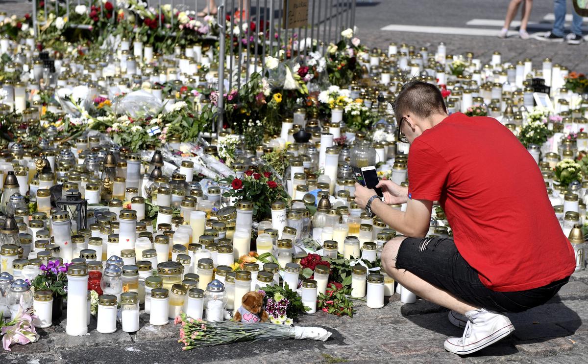 Mourners bring memorial cards, candles and flowers to the Turku Market Square, in Turku, Finland on August 20, 2017. (Lehtikuva/Vesa Moilanen/via REUTERS)