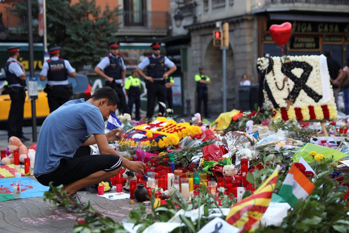 A man lights a candle at an impromptu memorial where a van crashed into pedestrians at Las Ramblas in Barcelona, Spain on August 21, 2017. (REUTERS/Susana Vera)