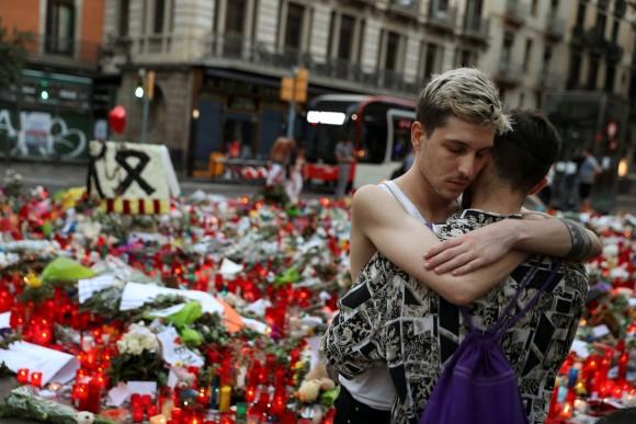 Two men react at an impromptu memorial where a van crashed into pedestrians at Las Ramblas in Barcelona, Spain August 21, 2017. (REUTERS/Susana Vera)