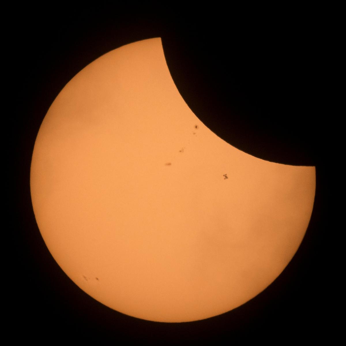 The International Space Station is seen in silhouette as it transits the sun during a partial solar eclipse seen near Banner, Wyoming, U.S., August 21, 2017. Courtesy Joel Kowsky/NASA/Handout via REUTERS