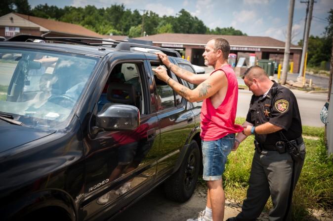 A man is searched by Deputy Sheriff Andy Teague for any drugs or paraphernalia in Montgomery County, Ohio, on Aug. 3, 2017. (Benjamin Chasteen/The Epoch Times)