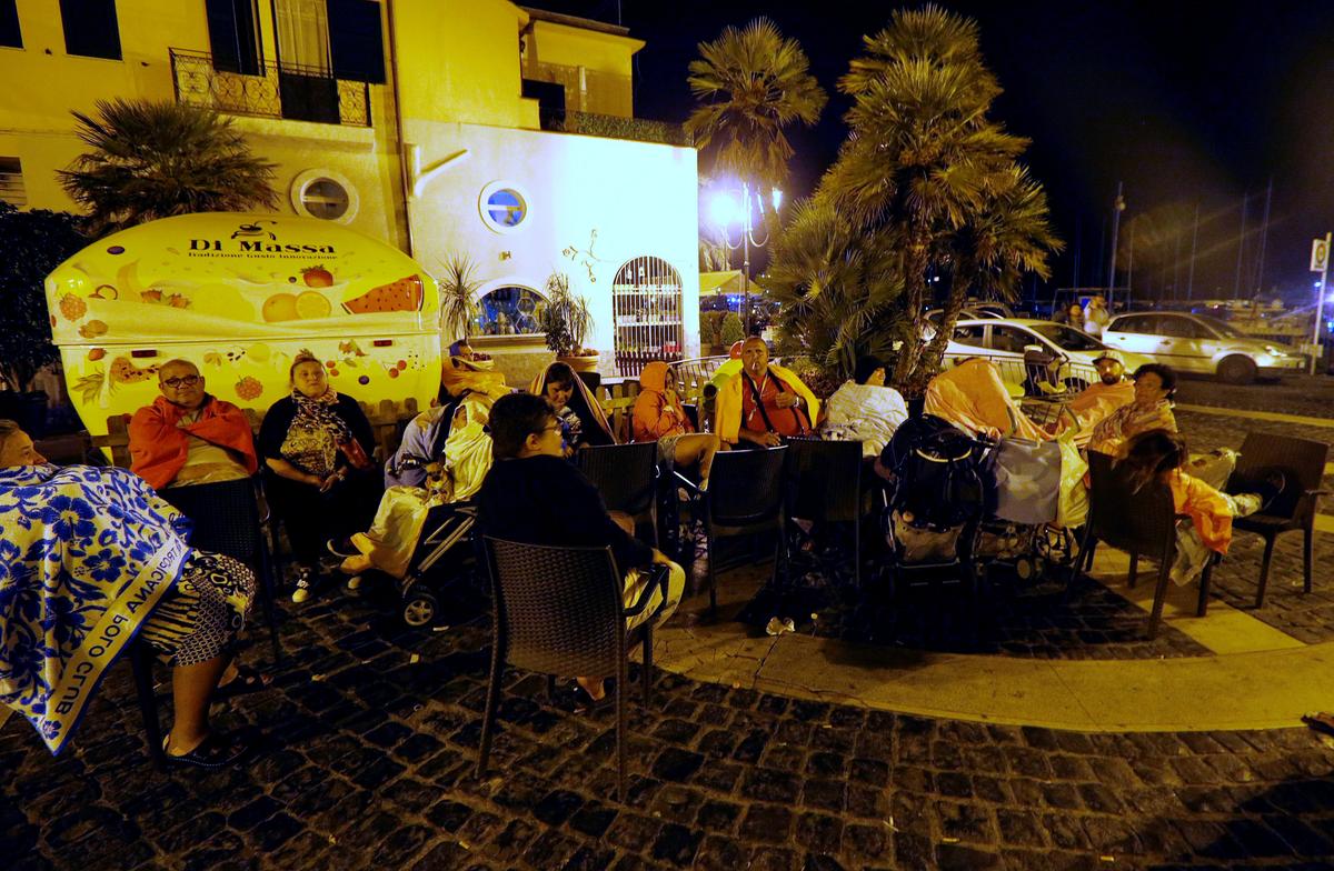 People sit in the street on early morning after an earthquake hit the island of Ischia, off the coast of Naples, Italy on August 22, 2017. (REUTERS/Ciro De Luca)