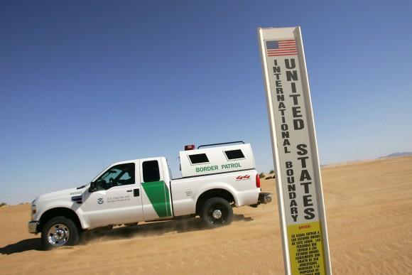 A Border Patrol vehicle passes an international border marker in the Colorado Desert at the Imperial Sand Dunes along the US–Mexico border between El Centro, Calif., and Yuma, Ariz., on April 5, 2008. (David McNew/Getty Images)