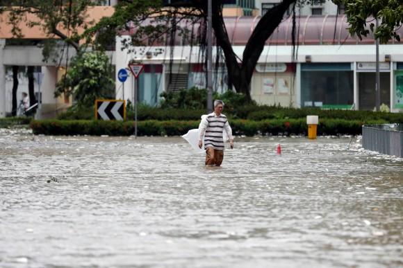 A man walks through a flooded street as Typhoon Hato hits Hong Kong, China August 23, 2017. (Reuters/Tyrone Siu)