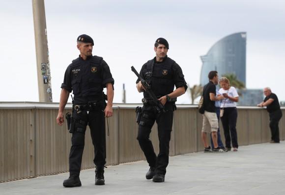FILE PHOTO: Armed Catalan Mossos d'Esquadra officers patrol along La Barceloneta beach in Barcelona, Spain, August 19, 2017. (Reuters/Sergio Perez)