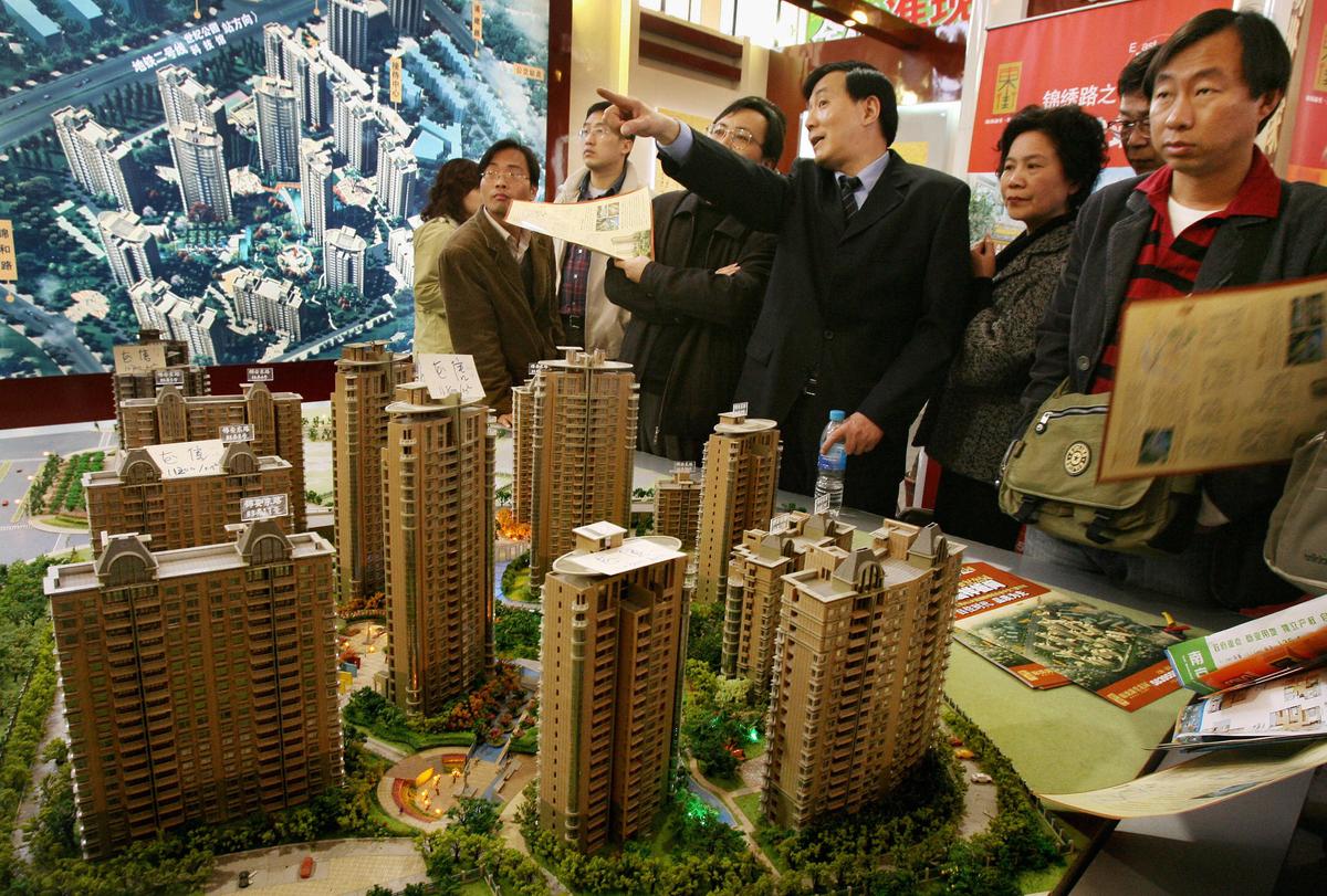 A property salesman (C) talks to potential buyers at a property exhibition in Shanghai on March 19, 2006. (MARK RALSTON/AFP/Getty Images)