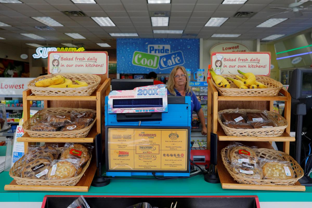 An employee stands behind a lottery machine at the Pride convenience store where a winning more than $750 million Powerball ticket was sold in Chicopee, Massachusetts, U.S., August 24, 2017. (REUTERS/Brian Snyder)