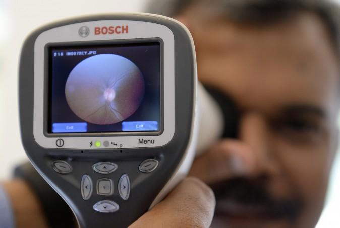 An employee of German technology company Bosch demonstrates the use of a Bosch eye care solution to check the retina of an eye with a digital camera at the company's headquarters in Gerlingen near Stuttgart, southwestern Germany, on April 29, 2015. (Thomas Kienzle/AFP/Getty Images)