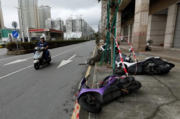 A man looks at motorcycles tipped over by strong wind from tropical storm Pakhar in Macau, China August 27, 2017. (Reuters/Tyrone Siu)