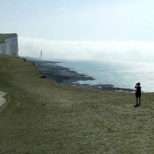A person takes photo of the mist near Beachy Head Lighhouse, near Eastbourne, Britain on Aug. 27, 2017. (Nick Harrison Neale via REUTERS)