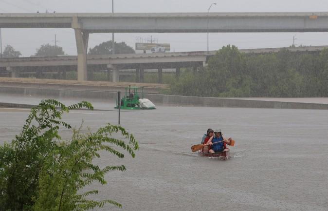Area residents use a kayak to rescue motorists stranded on Interstate highway 45, which is submerged from the effects of Hurricane Harvey seen during widespread flooding in Houston, Texas, on Aug. 27, 2017. (Richard Carson/Reuters)