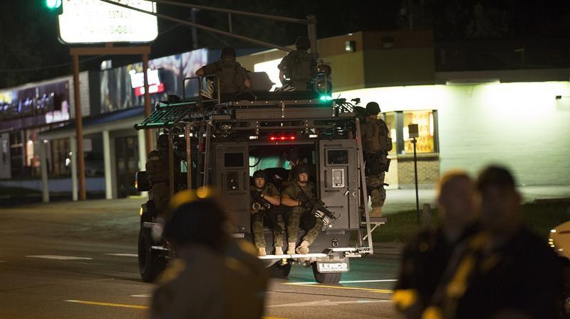 Police officers ride an armored vehicle as they patrol a street in Ferguson, Missouri on Aug. 11, 2014. (REUTERS/Mario Anzuoni)