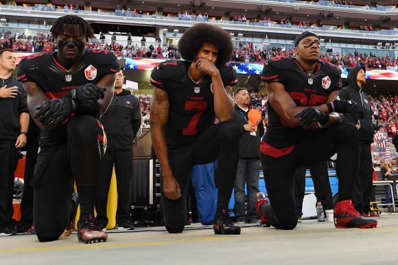 (L-R) Eli Harold No. 58, Colin Kaepernick No. 7, and Eric Reid No. 35 of the San Francisco 49ers kneel in protest during the national anthem prior to their NFL game against the Arizona Cardinals at Levi's Stadium on Oct. 6, 2016, in Santa Clara, Calif. (Thearon W. Henderson/Getty Images)