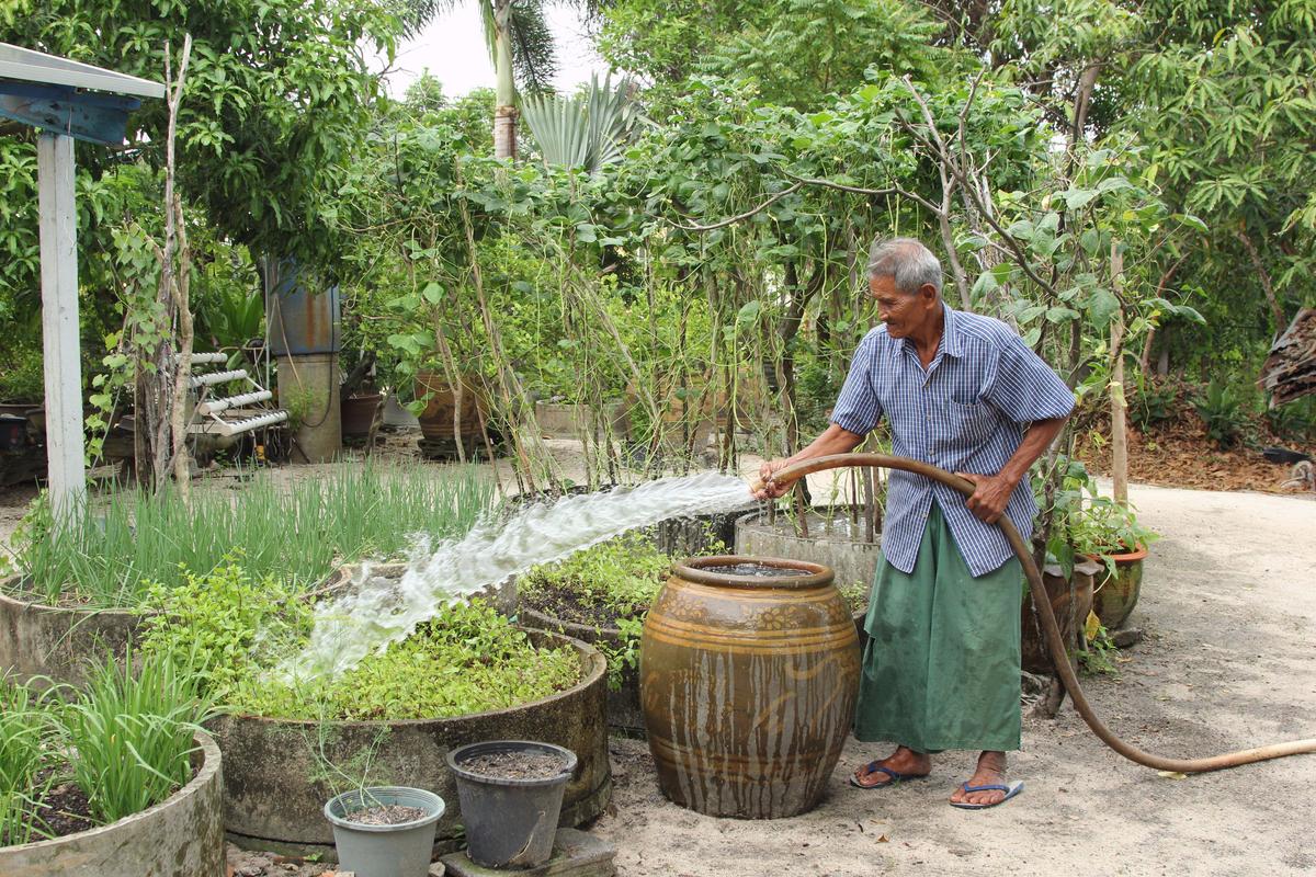 Noi Jaitang waters his garden in Map Ta Phut, Thailand, where the World Resources Institute has been working to address problems with water pollution. (Laura Villadiego)