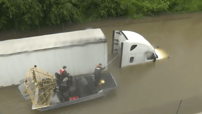 Rescue crews sidle up to a semitruck stuck in the floodwaters in Houston, on Aug. 27, 2017. (Screenshot via Brandy Smith/KHOU/Facebook)