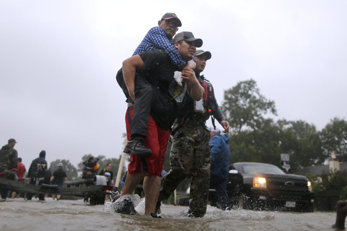 An elderly man is carried after being rescued from the flood waters of tropical storm Harvey in east Houston, Texas, U.S., Aug. 28, 2017. (Reuters/Jonathan Bachman)