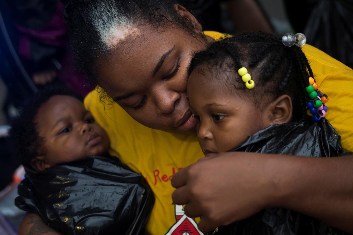 Laquanta Edwards holds her daughter Ladaja (R) and nine-month-old son LaDarius after they arrived to high ground by boat due to floods caused by Tropical Storm Harvey along Tidwell Road in east Houston, Texas, U.S. August 28, 2017. (REUTERS/Adrees Latif)