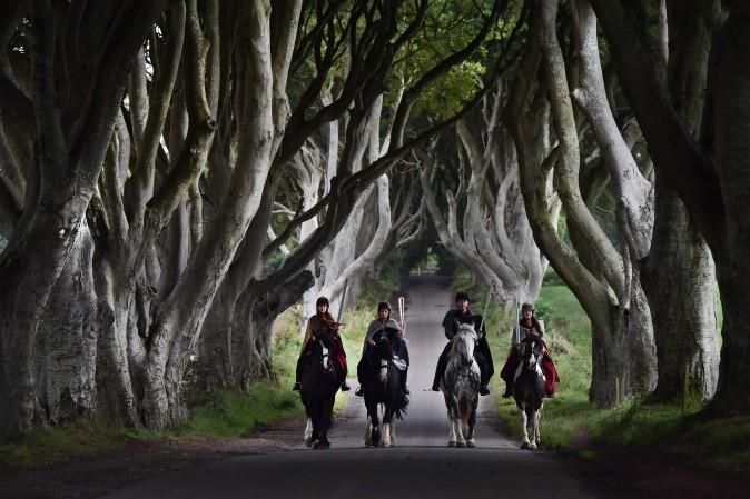 Four actors dressed in costumes related to "Game of Thrones" carry the Queen's Baton as they make their way along the Dark Hedges in Ballymoney, Northern Ireland, on Aug. 29, 2017. The Queen's Baton Relay is currently on a tour of the United Kingdom as it makes its way around Europe in preparation for the 2018 Commonwealth Games in Australia. The Dark Hedges featured as the King's Road in season two of drama series "Game of Thrones" has become a tourist mecca for fans of the television series. (Charles McQuillan/Getty Images)