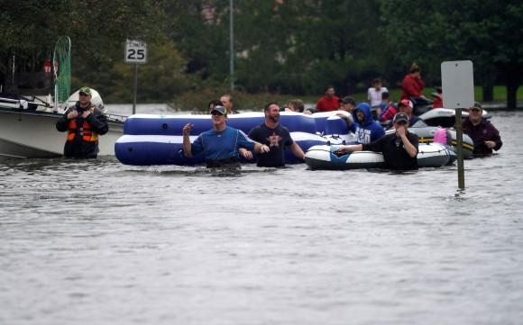 People are evacuated by volunteers in waist-deep floodwaters from Hurricane Harvey in Houston, Texas August 29, 2017. (Reuters/Rick Wilking)