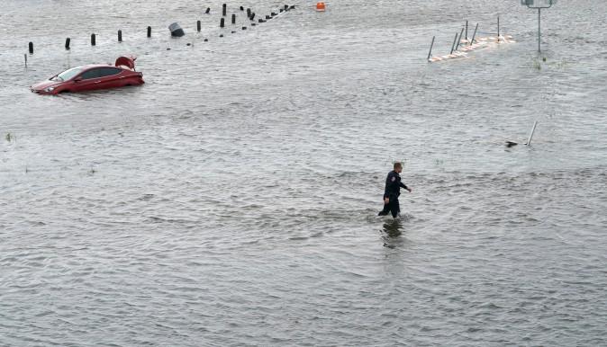 A police officer wades through the Hurricane Harvey floodwaters in Alvin, Texas August 29, 2017. (Reuters/Rick Wilking)