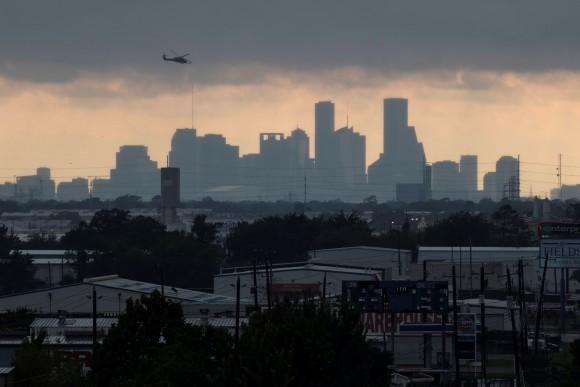 A helicopter hovers above the Houston skyline as sunlight breaks through storm clouds from Tropical Storm Harvey in Texas, U.S. August 29, 2017. (Reuters/Adrees Latif)