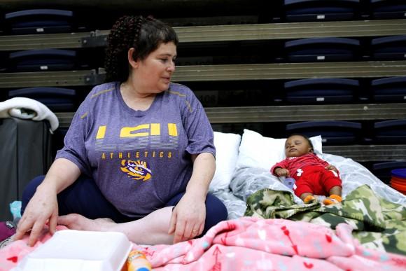 Denise Vital, who evacuated her flooded home from Tropical Storm Harvey, watches over her 3-month-old godson at the Lake Charles Civic Center in Lake Charles, Louisiana, U.S., on August 29, 2017. Vital, who's home was destroyed by Hurricane Rita in 2005 said, "You have to keep pushing forward." (Reuters/Jonathan Bachman)