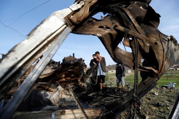People look at the wreckage of a taxi car destroyed by a Saudi-led air strike on a checkpoint of the armed Houthi movement near Sanaa, Yemen August 30, 2017. (Reuters/Khaled Abdullah)