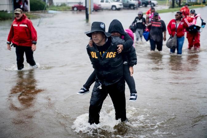 People walk to a Harris County Sheriff air boat while escaping a flooded neighborhood during the aftermath of Hurricane Harvey on Aug. 29 in Houston, Texas. (Brendan Smialowski/AFP/Getty Images)