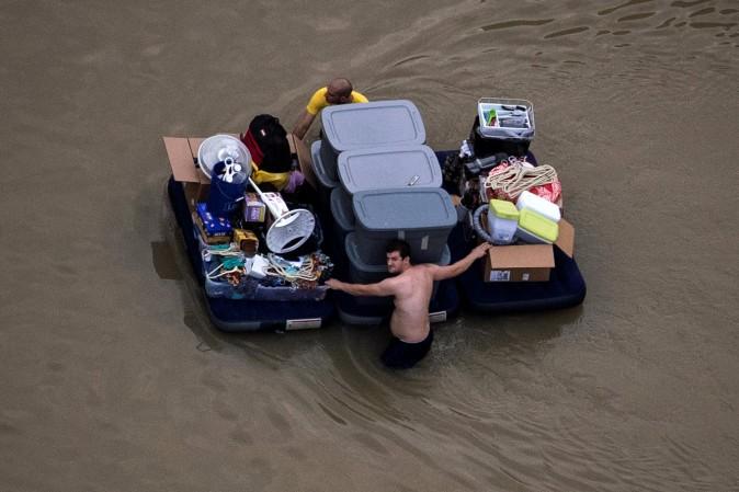 Residents wade with their belongings through floodwaters brought by Tropical Storm Harvey in Northwest Houston, Texas, on Aug. 30, 2017. (Adrees Latif/Reuters)