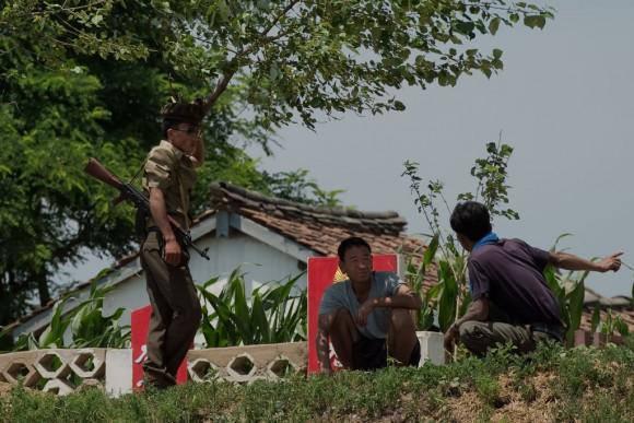 A North Korean soldier speaks with North Korean farmers on the banks of the Yalu River near Sinuiju, opposite the Chinese border city of Dandong on July 5, 2017. (Nicolas Asfouri/AFP/Getty Images)