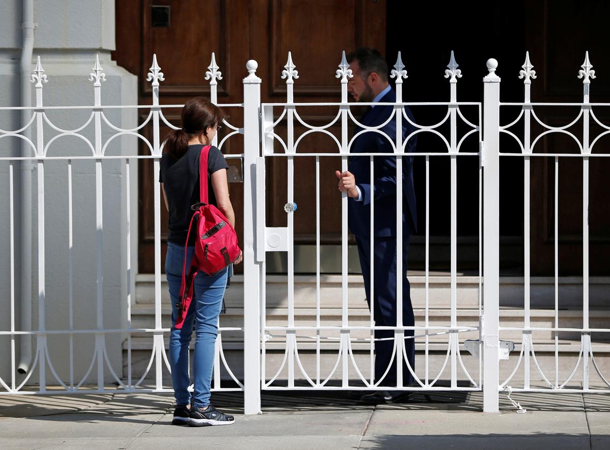 An unidentified woman talks with a man outside the gate at the entrance to the building of the Consulate General of Russia in San Francisco, Calif., on Aug. 31, 2017.   (REUTERS/Stephen Lam)