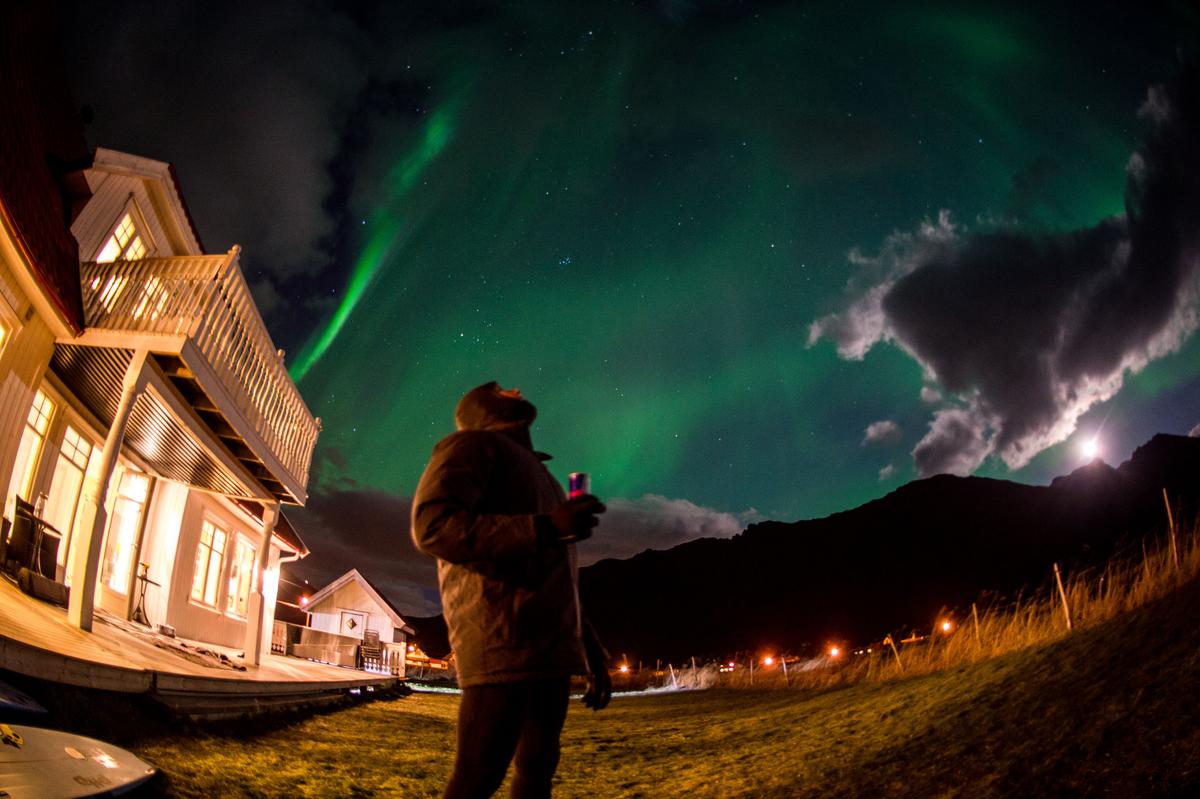 Mick Fanning is looking into the colorful night in Lofoten, Norway on Nov. 10, 2016. (Trevor Moran / Red Bull Content Pool)