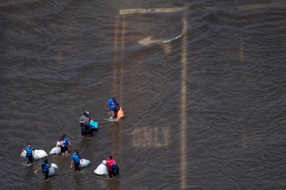 A group of people carry supplies through floodwaters caused by Tropical Storm Harvey in Port Arthur, Texas, Aug. 31, 2017. (Adrees Latif/Reuters)