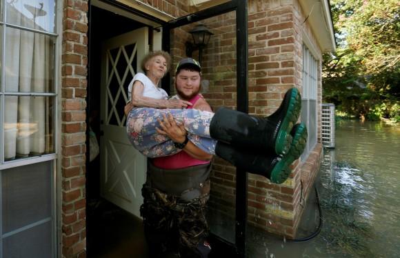 Nancy McBride is carried out of her flooded home by volunteer Cody Collinsworth, after returning home for the first time since Harvey floodwaters arrived in Houston, Texas, Sept. 1, 2017. (Rick Wilking/Reuters)