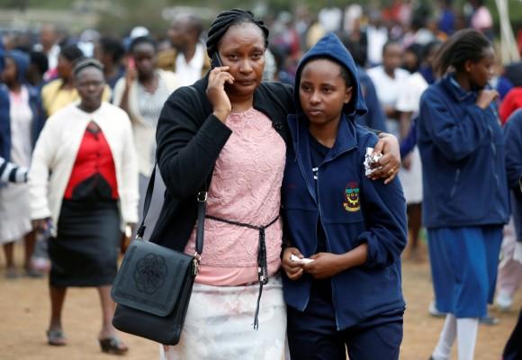 A parent embraces a student following a fire which burnt down one dormitory of Moi Girls school in Nairobi, Kenya September 2, 2017. (Reuters/Baz Ratner)