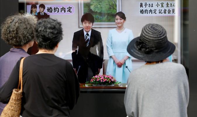 People look at a street monitor showing a news report about the engagement of Princess Mako, the elder daughter of Prince Akishino and Princess Kiko, and her fiancee Kei Komuro, a university friend, in Tokyo, Japan on Sept. 3, 2017. (Reuters/Toru Hanai)