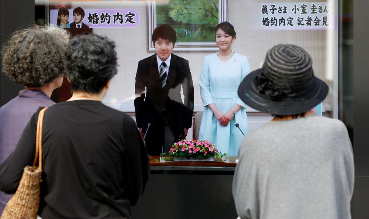 People look at a street monitor showing a news report about the engagement of Princess Mako, the elder daughter of Prince Akishino and Princess Kiko, and her fiancee Kei Komuro, a university friend of Princess Mako, in Tokyo, Japan on Sept. 3, 2017. (REUTERS/Toru Hanai)