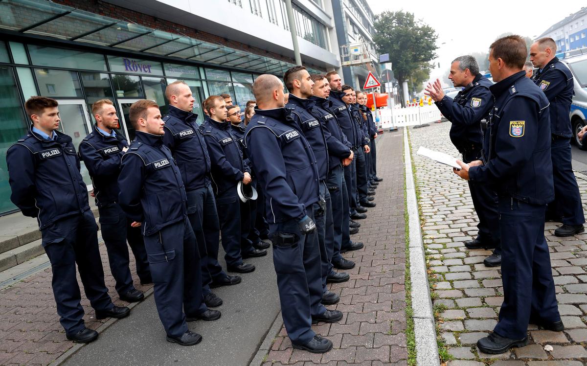 Police officers get their instructions as 60,000 people in Germany's financial capital are about to evacuate the city while experts defuse an unexploded British World War Two bomb found during renovations on the university's campus in Frankfurt, Germany on Sept. 3, 2017. (REUTERS/Kai Pfaffenbach)