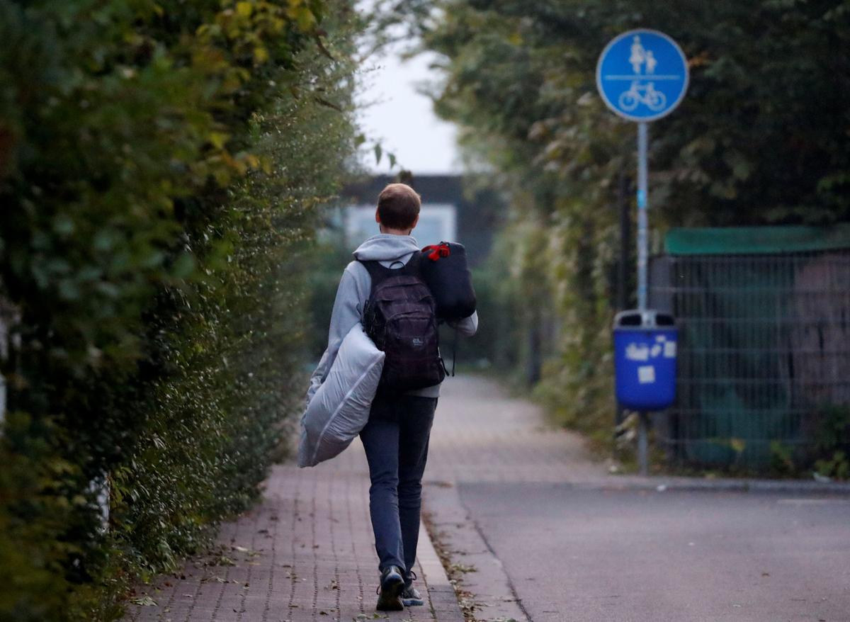 A young man carries his pillow and a sleeping bag as some 60,000 people in Germany's financial capital are about to evacuate the city while experts defuse an unexploded British World War Two bomb found during renovations on the university's campus in Frankfurt, Germany on Sept. 3, 2017. (REUTERS/Kai Pfaffenbach)
