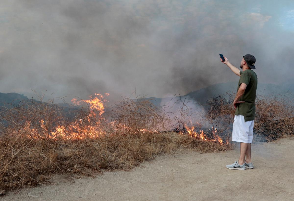  A spectator films the La Tuna Canyon fire over Burbank. (REUTERS/ Kyle Grillot)