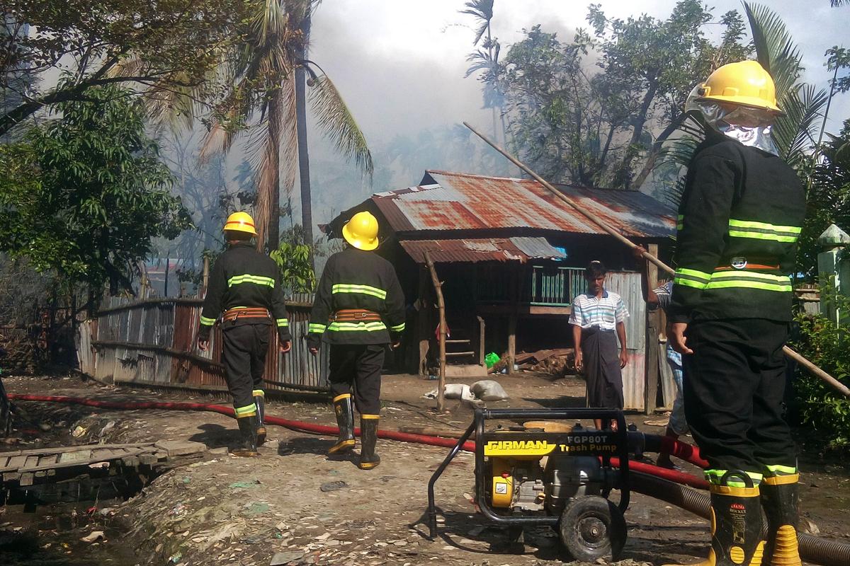 This picture taken on August 27, 2017 shows firefighters attempting to extinguish fires from houses burnt by Rohingya fighters at the Maungdaw township in Rakhine State in Burma.  (STR/AFP/Getty Images)